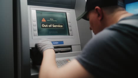 cleaner, cleaning service specialist wiping out of service atm with microfiber cloth, cleaning away dirt and dust, preparing automated teller machine, cash machine for using. public banking equipment.