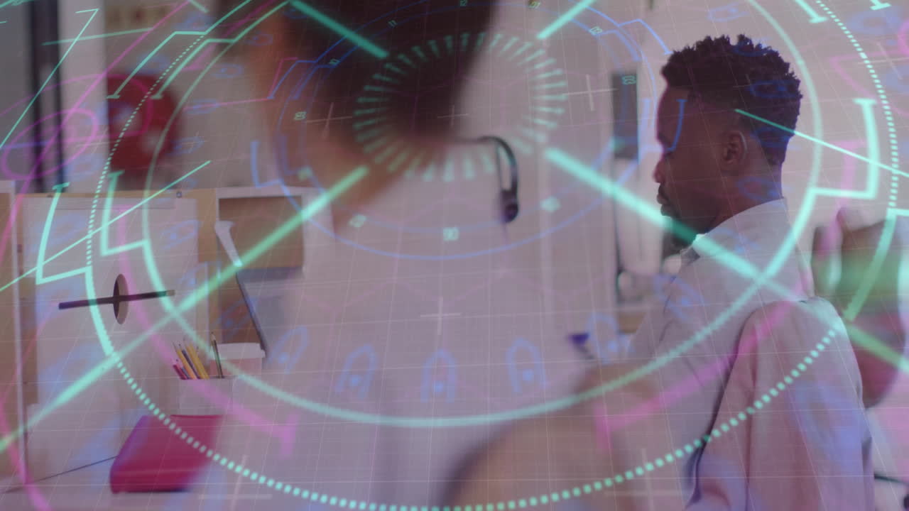 Mid-adult male worker analyzing finance HUD overlay while female colleague tapping tablet device