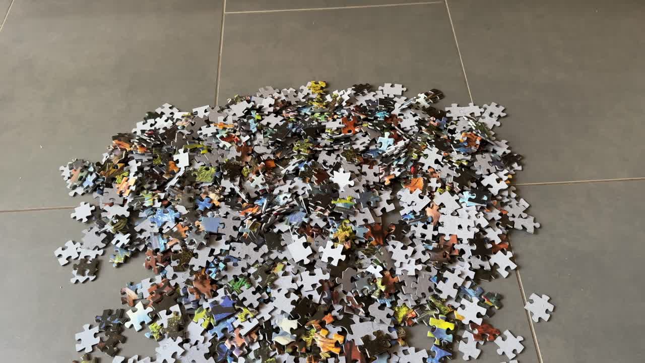 Jigsaw Puzzle Pieces in Large Pile on Floor Close-Up Showing Mixed Colours and Irregular Shapes