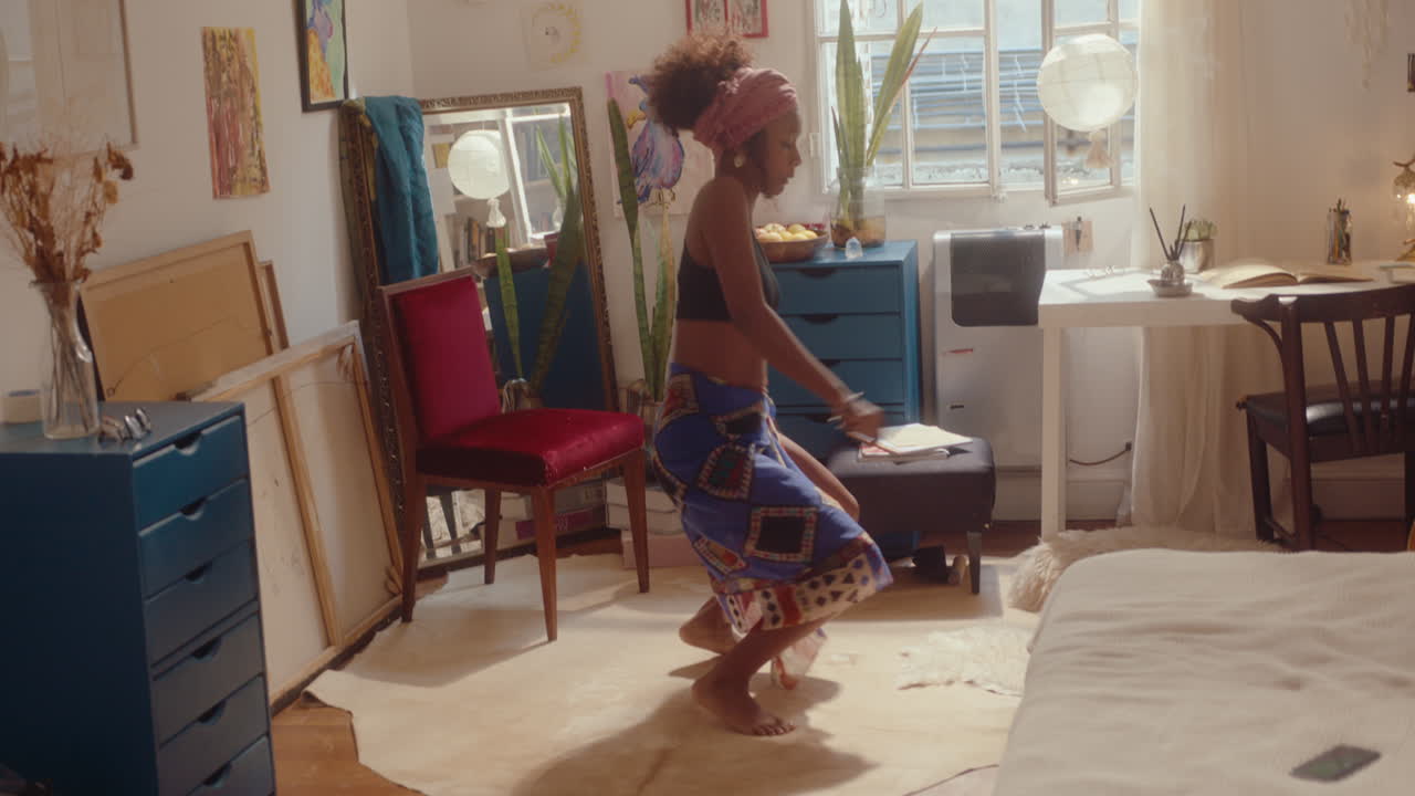 Attractive African-American Girl in Pareo Dancing in Sunlit Room