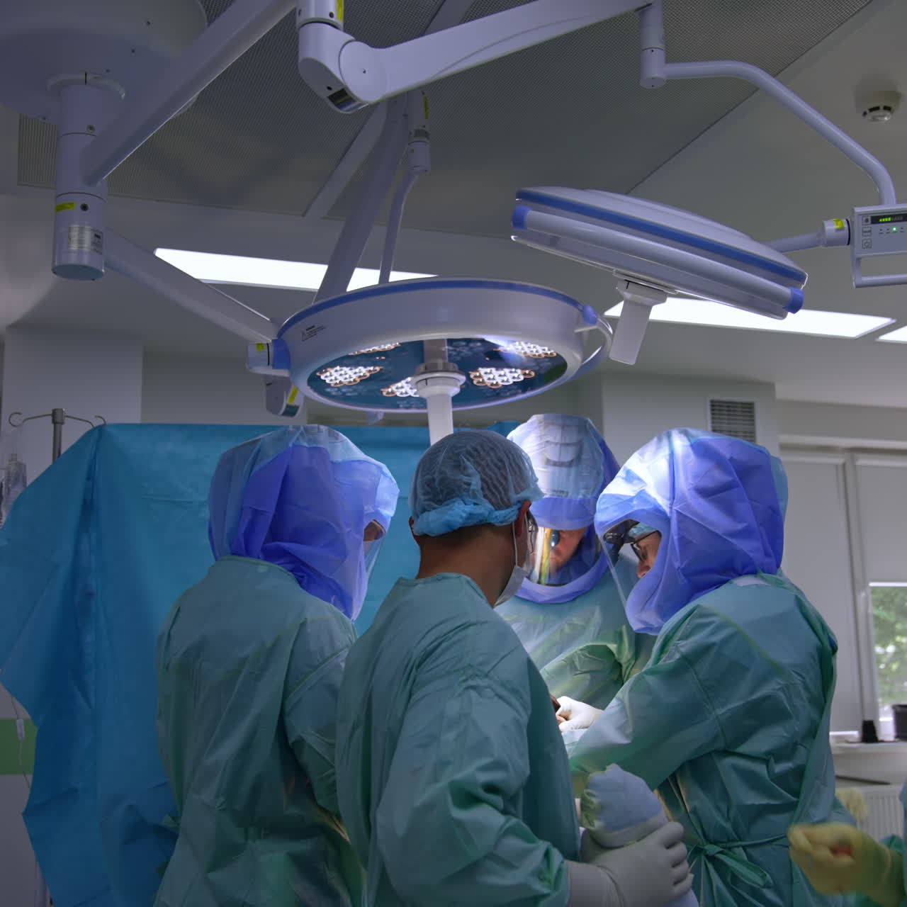Surgical team cooperating at trauma surgery. Female scrub nurse passing tools quickly to the doctors