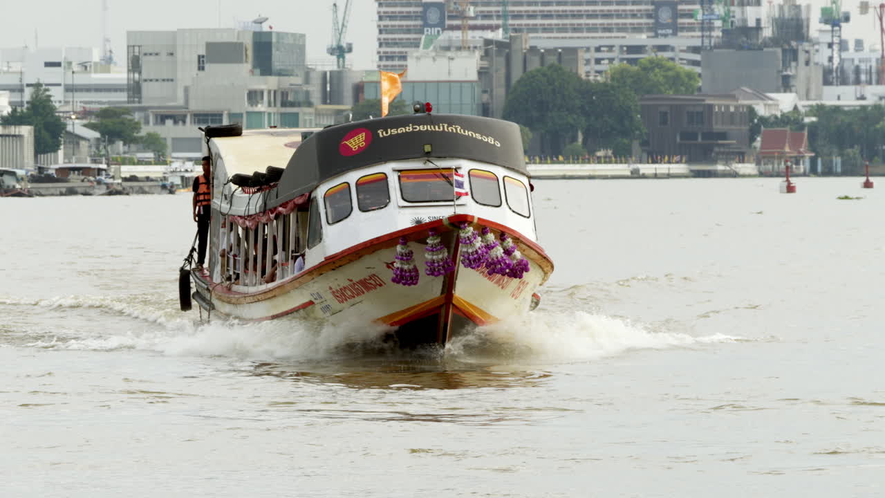 Express Boat on the Chao Phraya River in Bangkok Approaching the Pier for Passenger Services, Vital for Waterborne Travel and River Commuting in the City