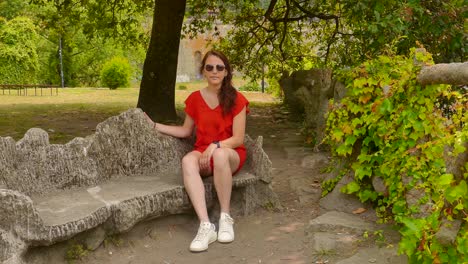 woman sitting on rock bench in virtudes garden in porto, portugal - wide