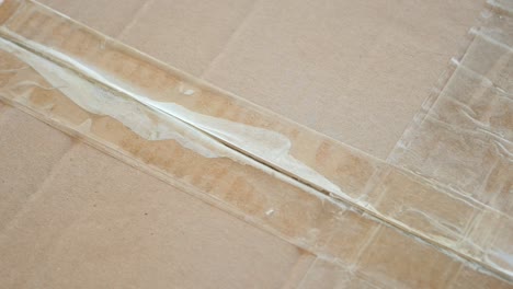 opening a cardboard box with a box cutter