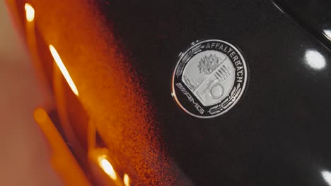 close up of car manufacturer logo on vehicle, red hue illuminate, czechia