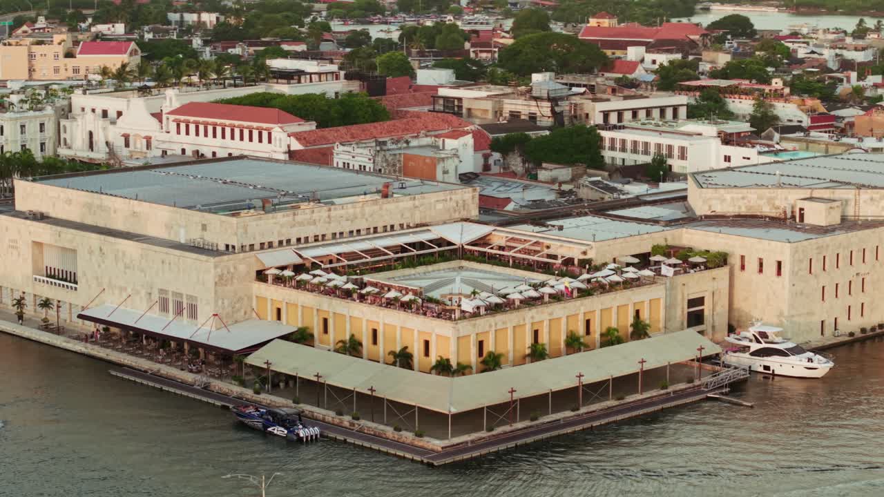 Orbital aerial shot of convention center with tourists enjoying sunset, cartagena de indias, colombia