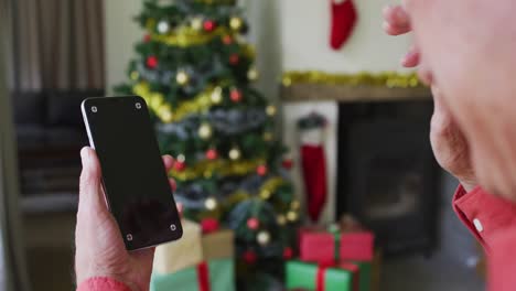 Happy-caucasian-senior-man-on-video-call-on-smartphone-with-copy-space-at-christmas-time