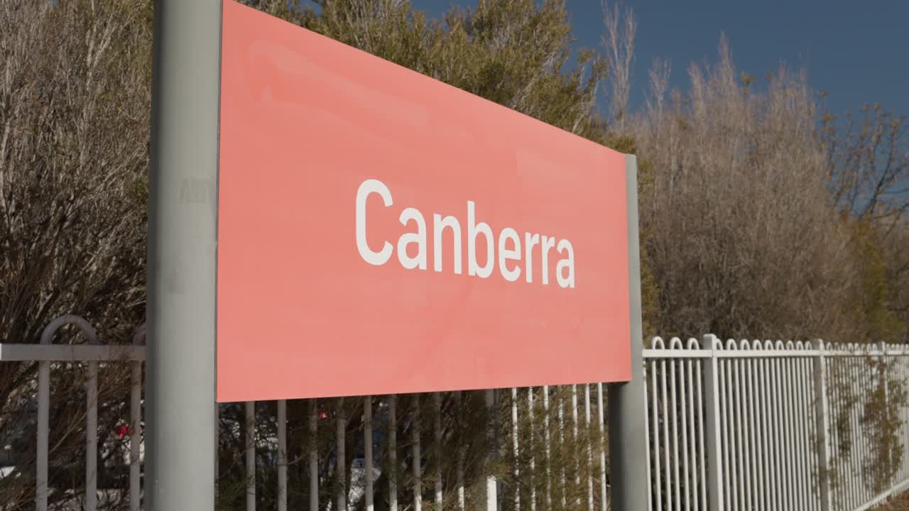 Low angle slow motion shot of the Canberra train station sign with sky in background