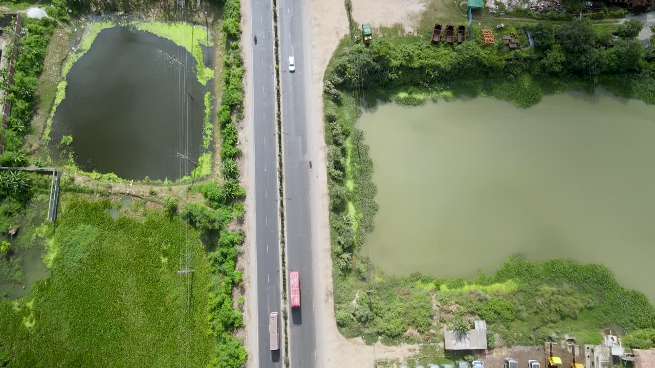 호수 근처 다카 시의 아름다운 도로에서 차량들이 움직이고 있다