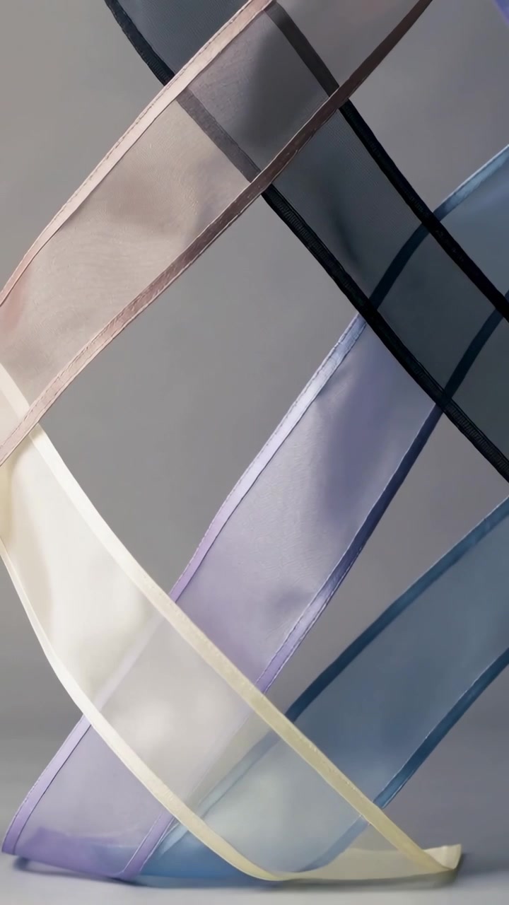 Vertical video: Gliding sheer ribbons by breeze, sliding in studio, forming color blends with tab