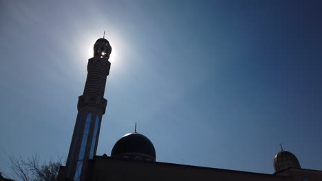 sun peeking through the minaret of the madinah masjid mosque on danforth avenue in toronto, wide shot
