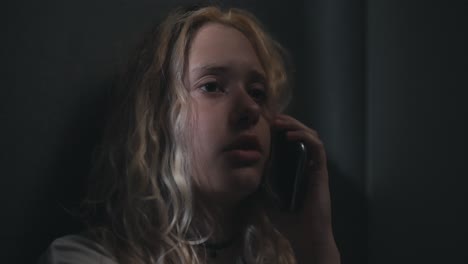 sad blonde girl talking on the phone after a shower late at night. communication instead of sleep with loved ones at night