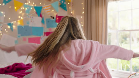 una niña feliz bailando en el dormitorio divirtiéndose una mañana juguetona usando pijama disfrutando del fin de semana en casa