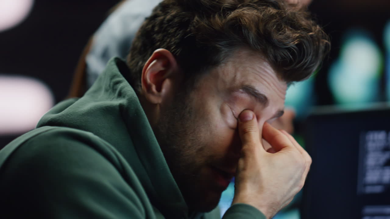 sviluppatore stanco strofinando gli occhi lavorando in ufficio fino a tardi con una collega donna close-up