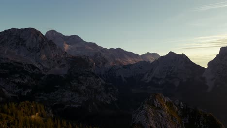 Backward-movement-with-a-drone-filmed-beautiful-mountains-in-the-alps-at-sunrise-with-a-clear-sky-in-4k