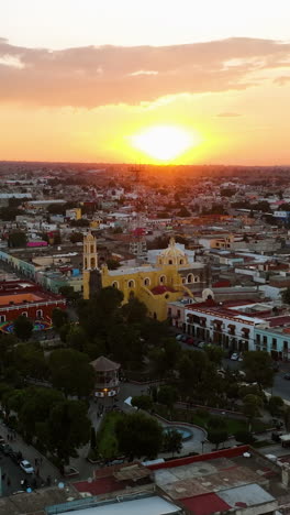 vertical drone shot circling the church in huamantla, colorful sunset in mexico