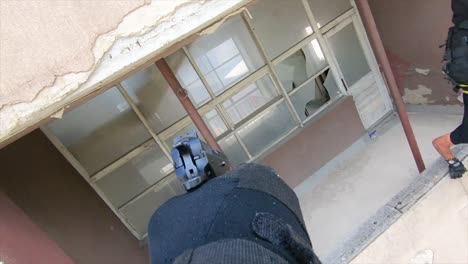 agente de las fuerzas especiales en una misión bajando un edificio con cuerdas y apuntando un arma pov