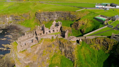 Toma-Orbital-Aérea-Moviéndose-En-Sentido-Antihorario-Sobre-El-Castillo-De-Dunluce-En-Irlanda-Del-Norte.