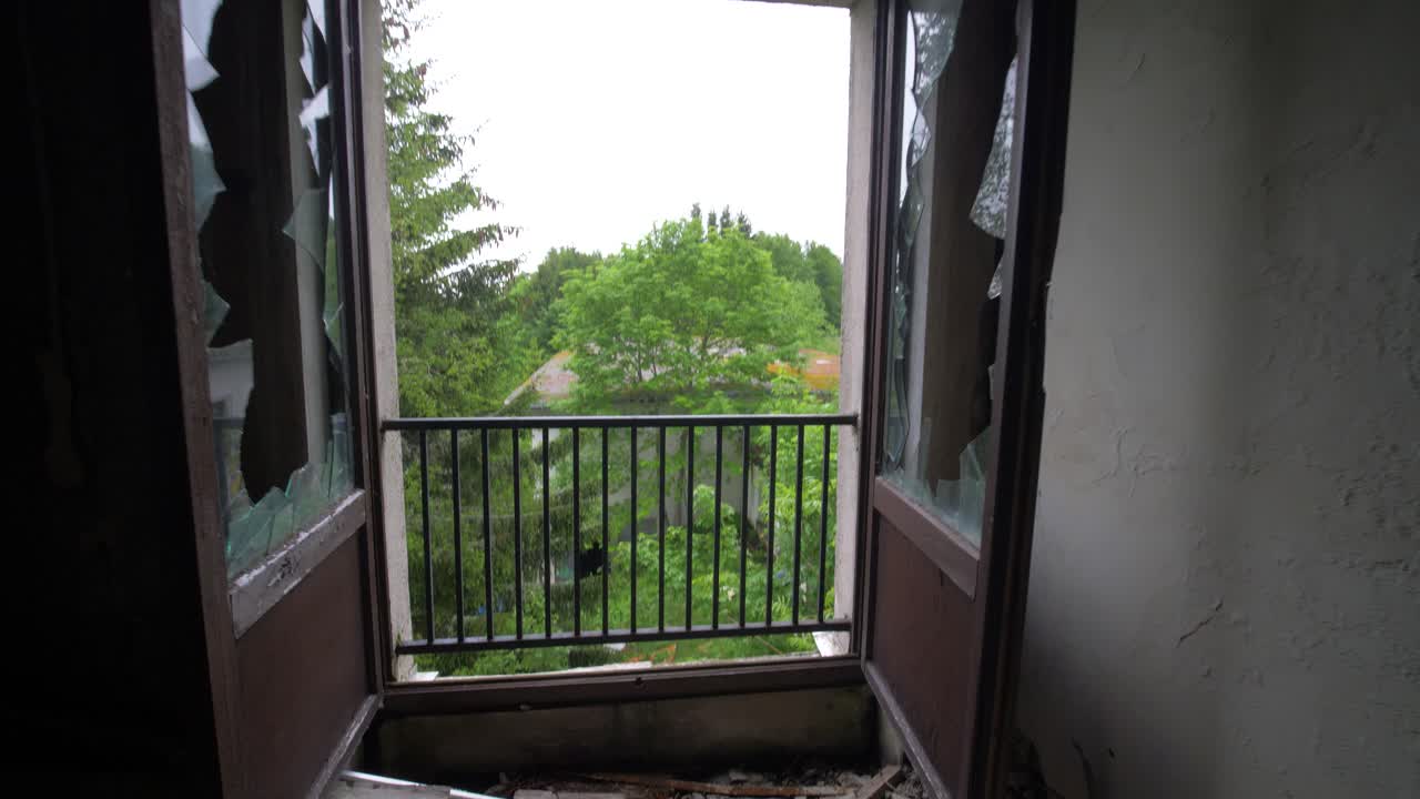 vista de la naturaleza desde una habitación de hotel abandonada a través de una ventana perdida en francia en cámara lenta