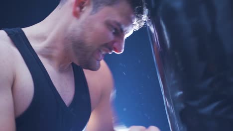 close-up male boxer punching a punching bag. focused and serious male boxer.