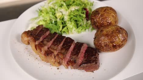 cena de bistec con patatas asadas y ensalada