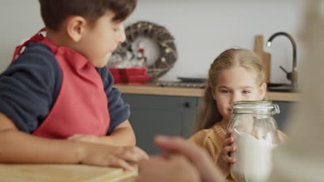 video of little girl bringing a jar of flour for baking