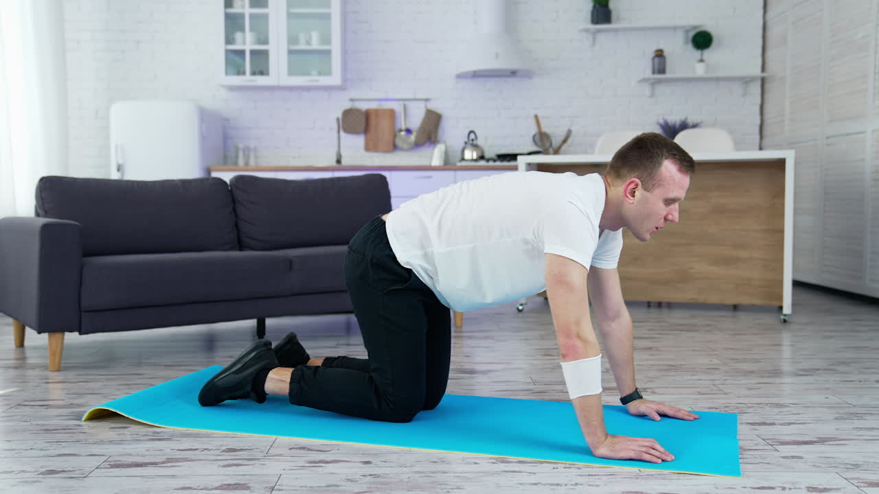 Quarantine working out in home. Healthy strong man training indoor.