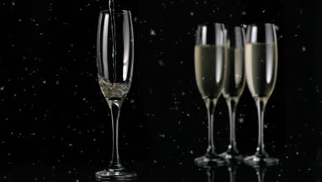 animation of white specks floating over glasses of champagne on black background