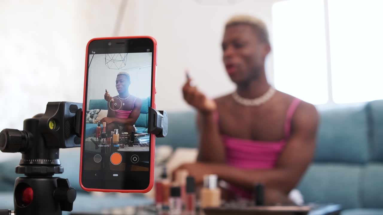 Persona gender-fluid che registra un tutorial di trucco a casa