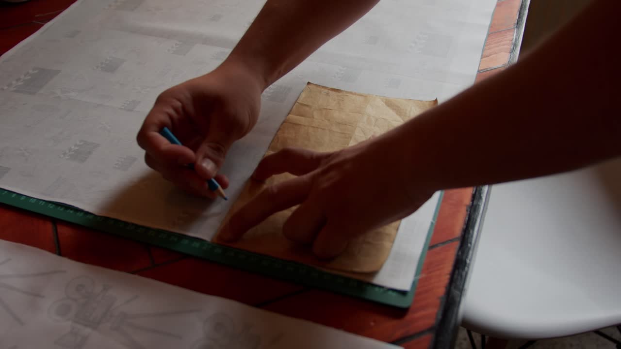 Marking out a pattern for fabric by hand. Natural light. Slow motion.