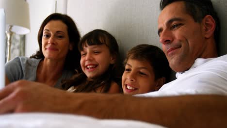 Eltern-Und-Kinder-Benutzen-Laptop-Auf-Dem-Bett-Im-Schlafzimmer