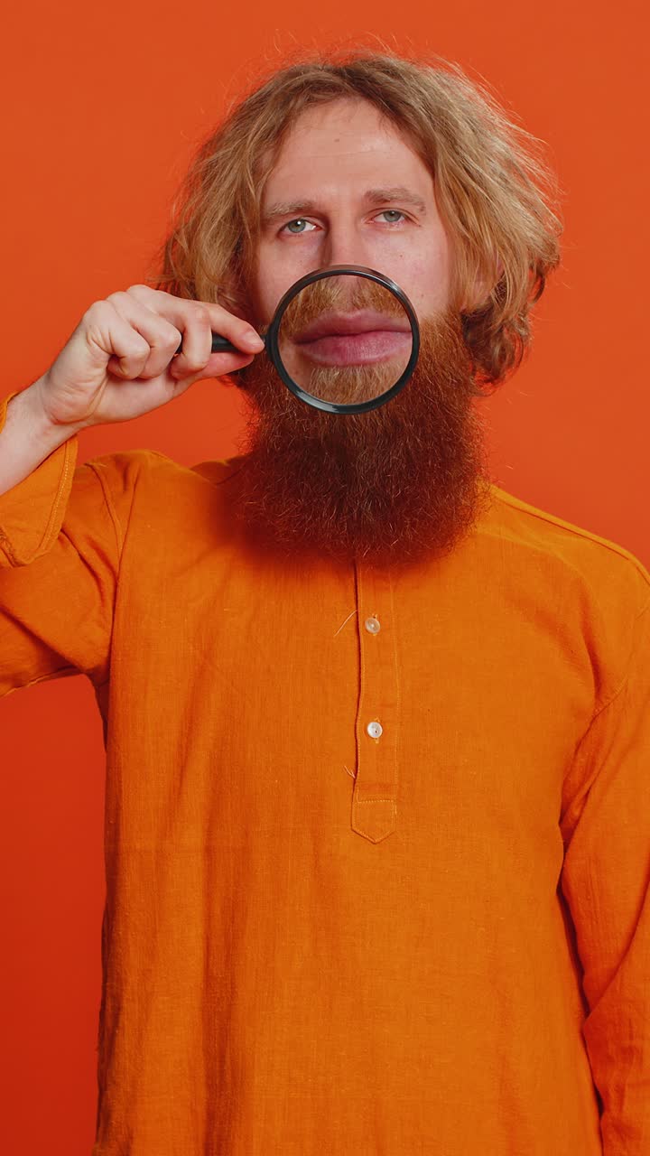 Happy smiling caucasian man holding magnifier glass on teeth health care hygiene stomatology concept