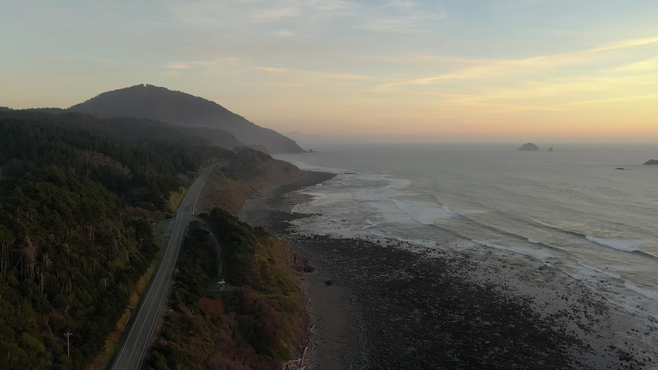 vista aérea de la carretera de la costa de oregon pasando por el parque estatal humbug mountain en una puesta de sol