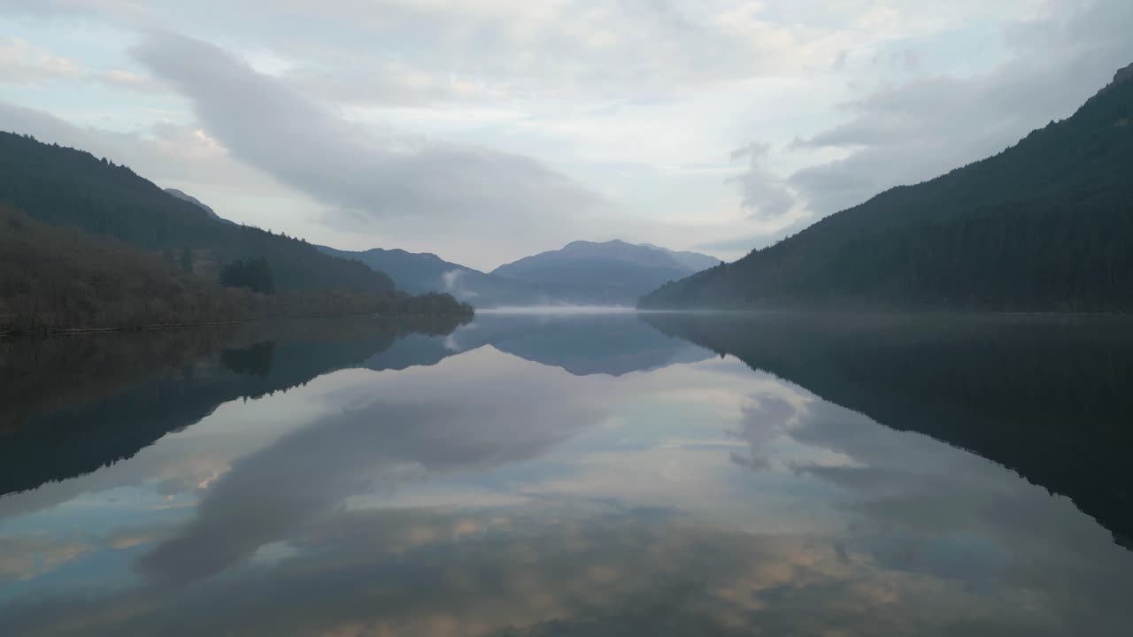 Drone Flight Over Mirror-Like Water with Mountain Scenery