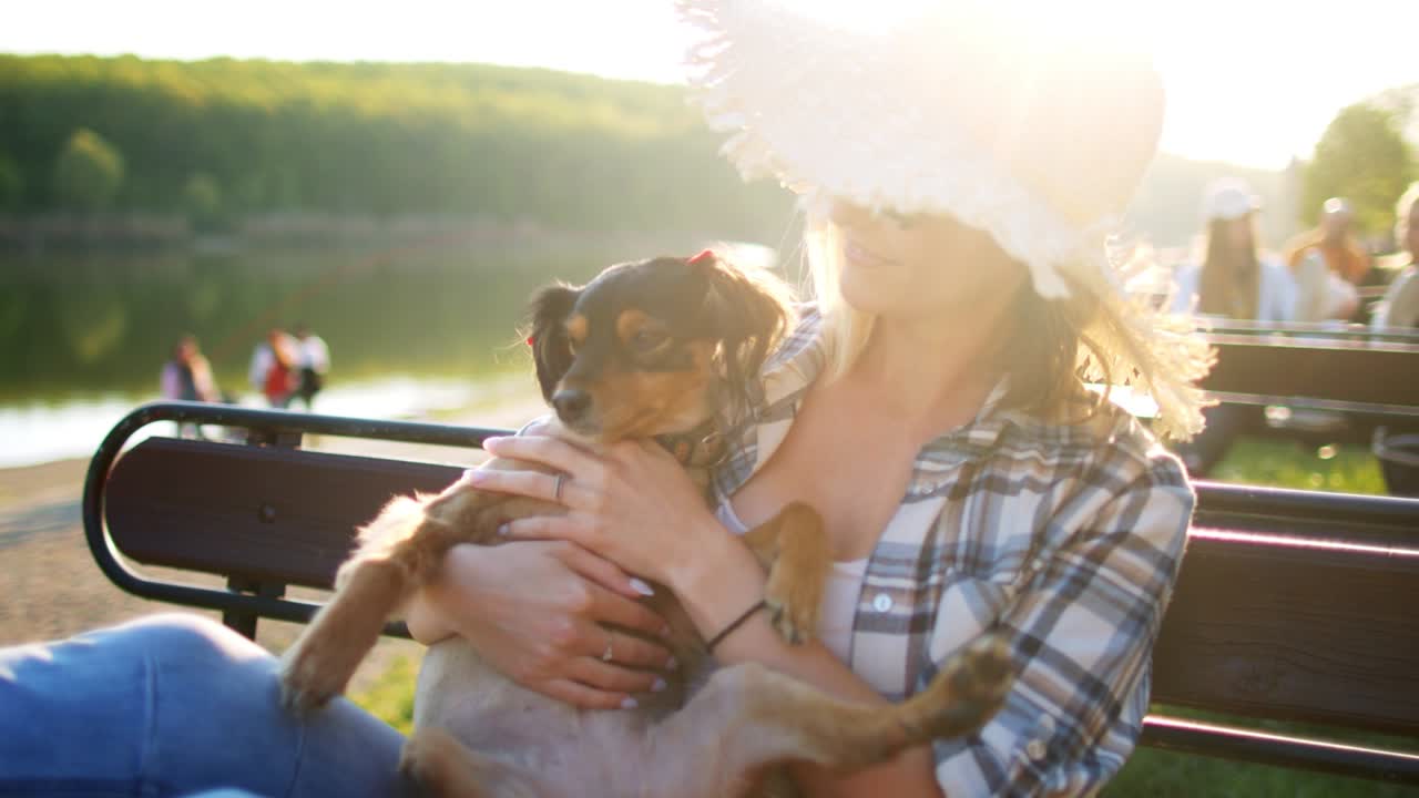 어린 여자가 개와 함께 벤치에서 휴식을 취하고 있습니다.