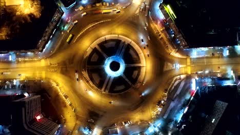 drone camera spin around crossroads night city. nightlife road with yellow light