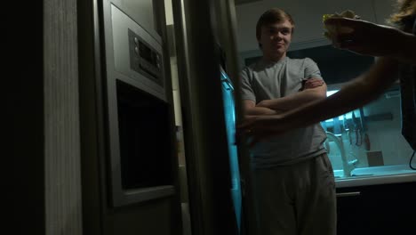 woman searching the refrigerator at night