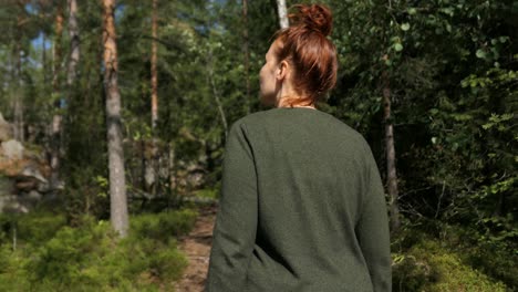 Woman-walking-in-forest,-enjoying-nature-walk,-back-view