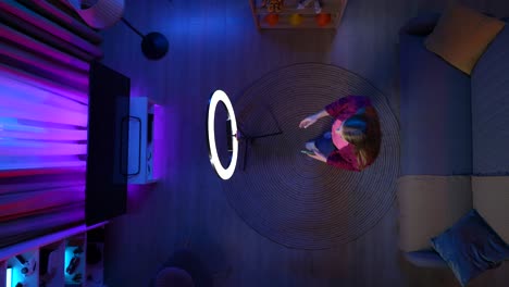 woman using ring light for video call at home at night.