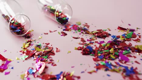 Champagne glasses with confetti on pink background at new year&#039;s eve