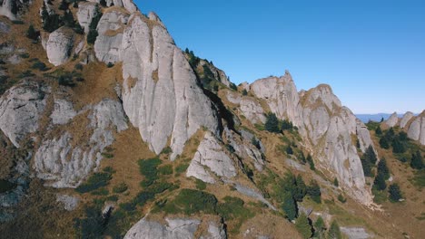 Drone-flying-up-revealing-a-unique-mountain-peak-with-oddly-shaped-stones