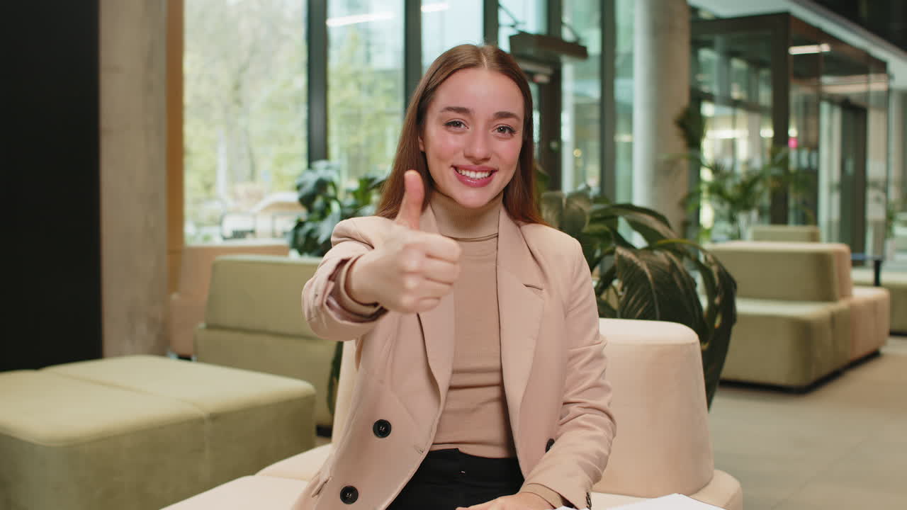 미소 짓는 백인 젊은 사업가 여자 의 초상화 호텔 로비 에서 엄지손가락을 보여주는 공식