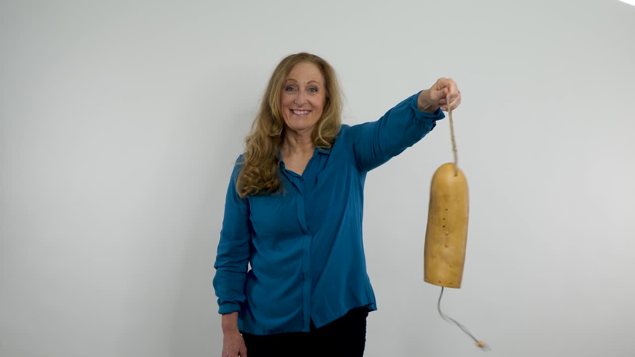 Una donna dai capelli rossi che tiene in mano uno strumento musicale a zucca