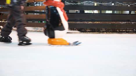 people ice skating at an outdoor rink at night