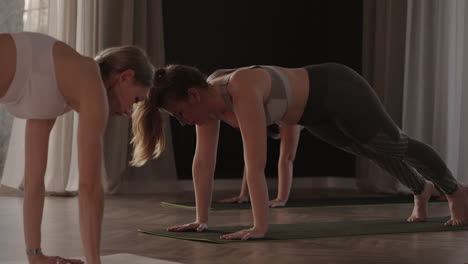 a group of women is engaged in stretching and balance with an instructor in a beautiful hall with large windows. healthy lifestyle group classes. joint training a common spirit