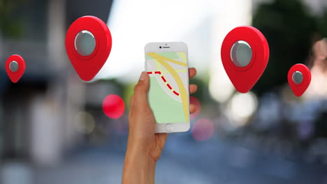 múltiples pines de ubicación flotando contra la mano usando un teléfono inteligente
