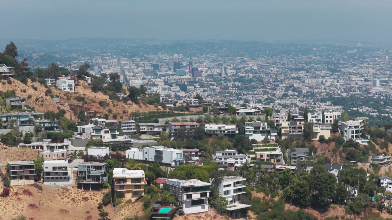 Ampia ripresa aerea in dolly di case in collina che si affacciano su Los Angeles a Beverly Hills, California. 4K.