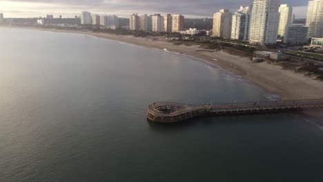 toma aérea inclinada hacia arriba del embarcadero y edificios de apartamentos en punta del este, uruguay