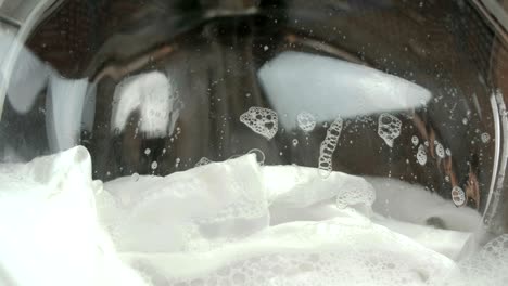 white linen is washed in the washing machine close-up.
