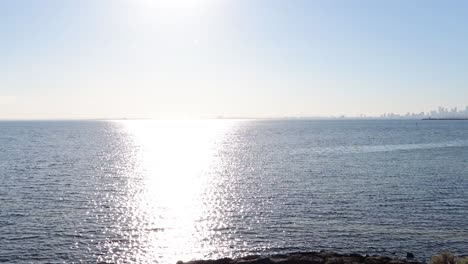 sunrise over ocean with city skyline